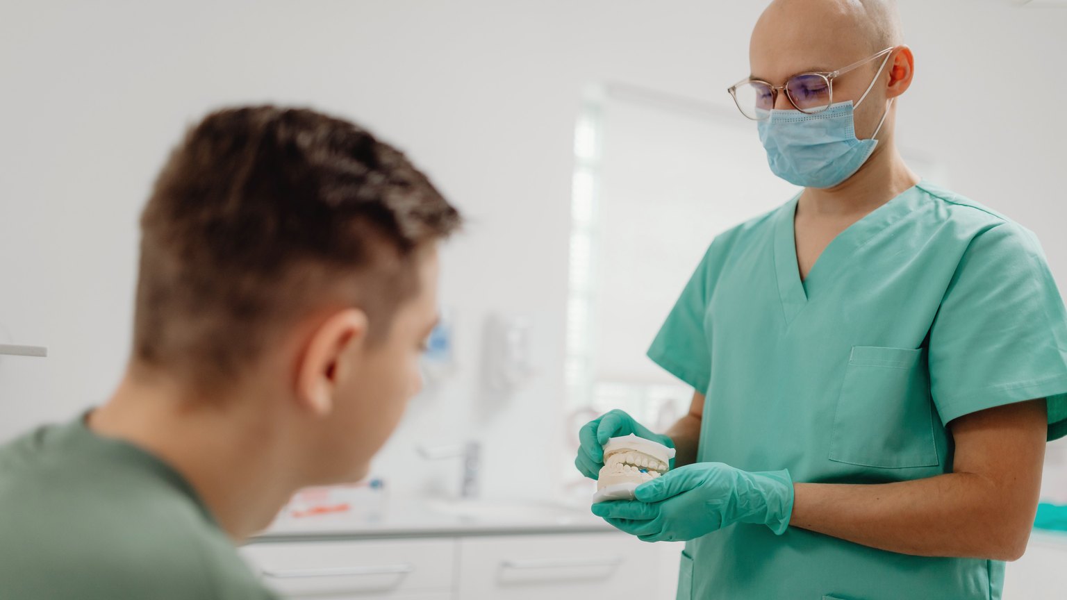 A dentist explaining treatment options with a tooth model